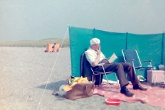 21 Opa met een sigaartje en een zakdoek op zijn hoofd voor de zon op het strand van Hoek van Holland